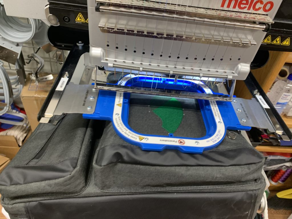 Automated embroidery machine producing customized business logos for apparel in the Rifle, CO area.